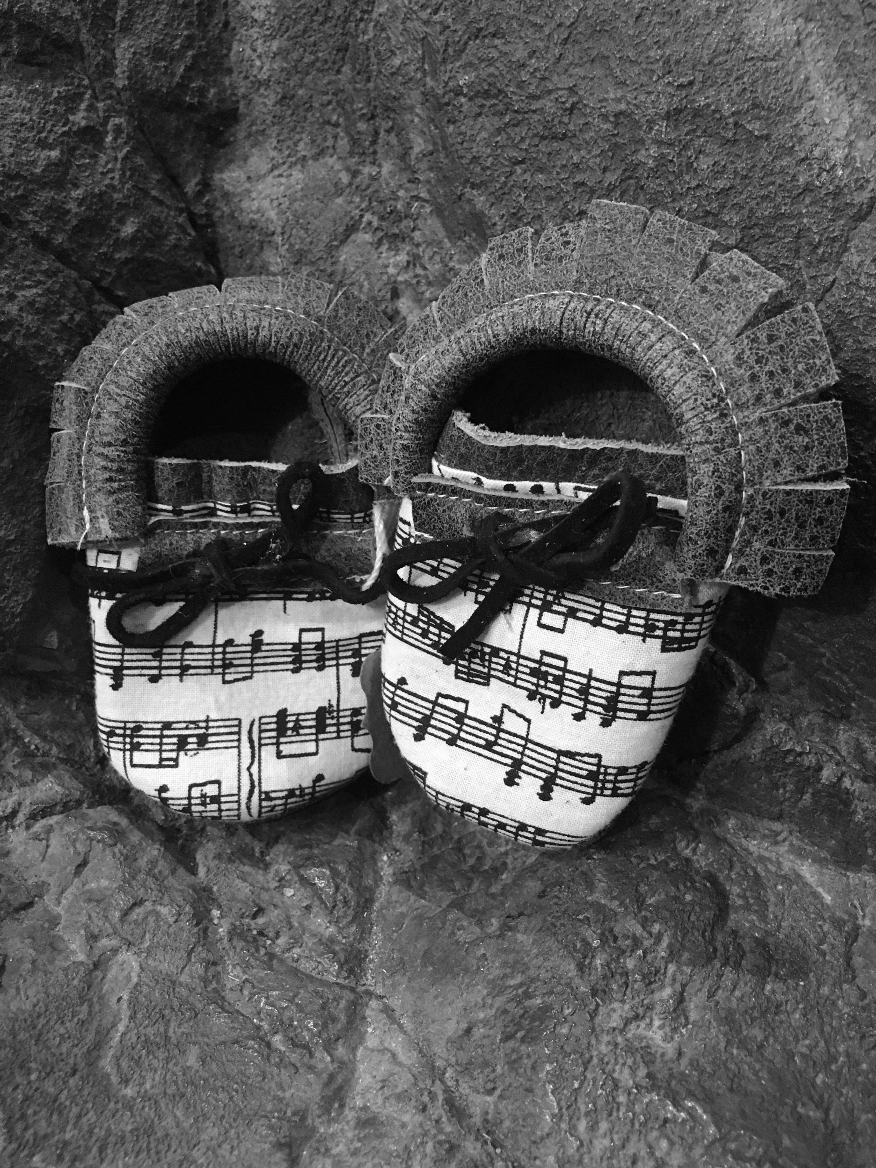 Black or grey leather moccs with short fringe and music toe toppers.